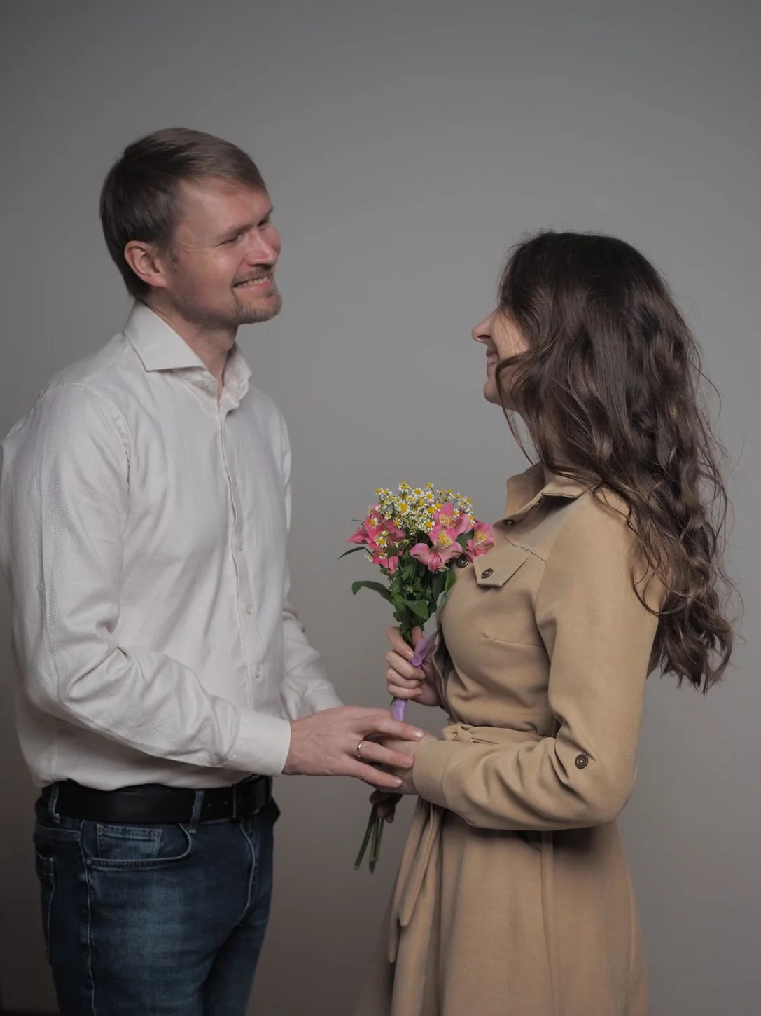 Парная фотосессия с букетом на спокойном сером студийном фоне